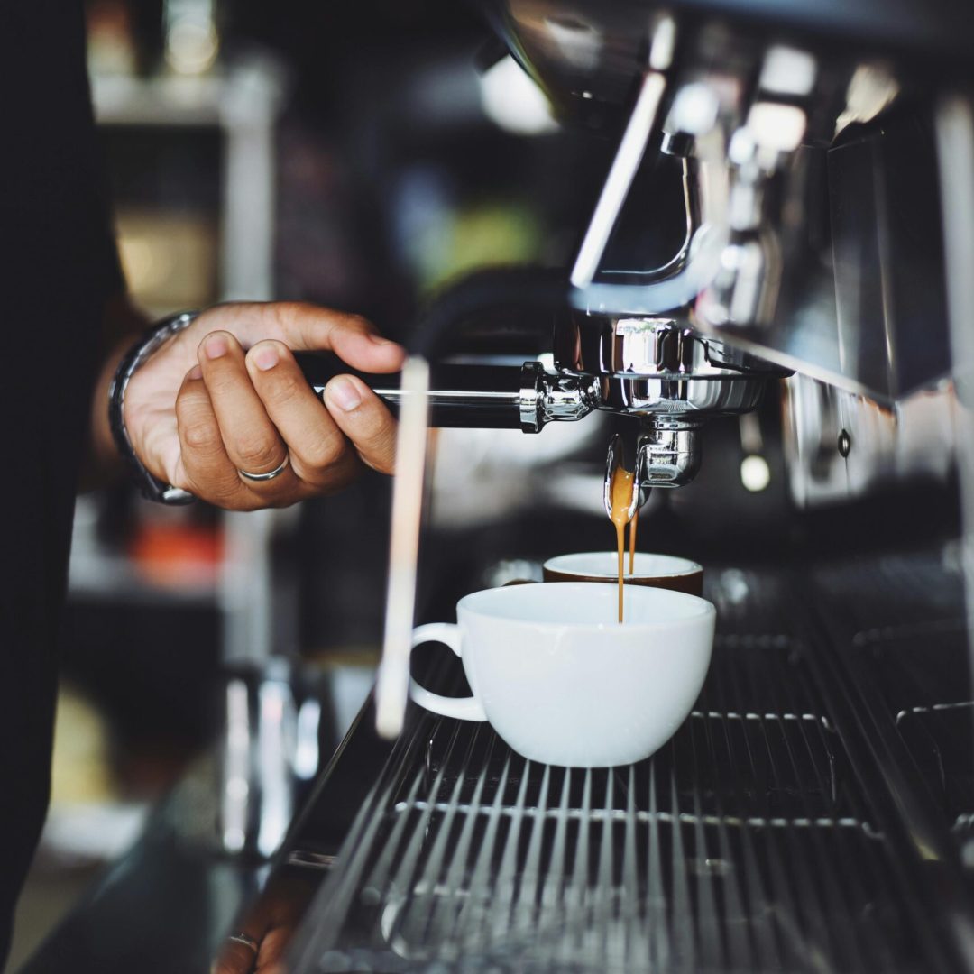 pexels-photo-302902-302902 Close-up of a barista preparing espresso in a café using a machine